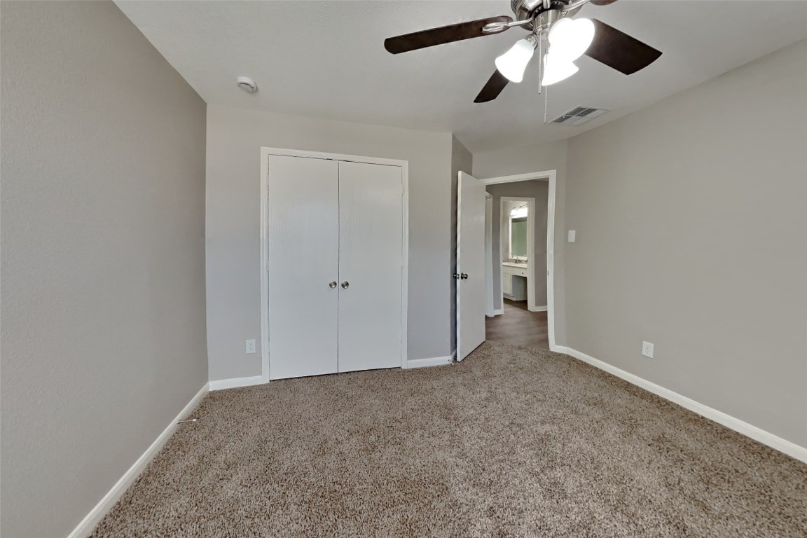 6423 Lily Hollow Court Spring, TX 77379 - Photo 12 of 20 an empty room with a chandelier fan and closet area