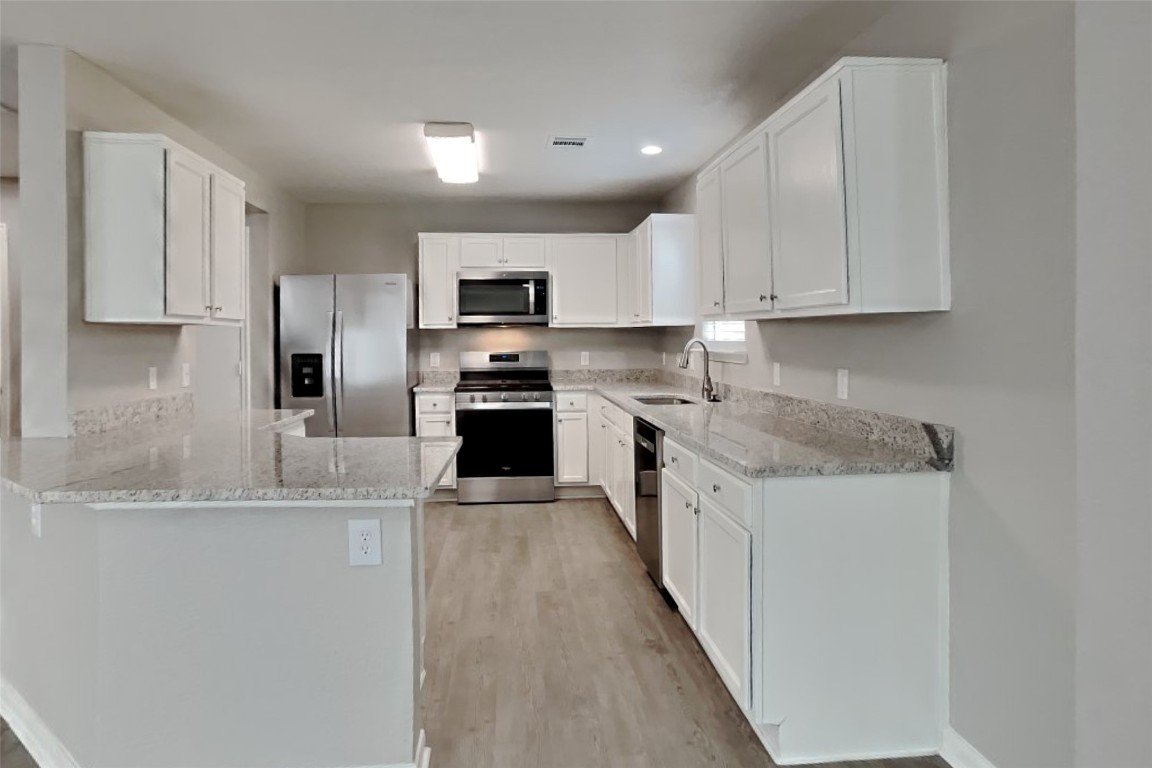 6423 Lily Hollow Court Spring, TX 77379 - Photo 4 of 20 a kitchen with kitchen island granite countertop a sink stove microwave and refrigerator