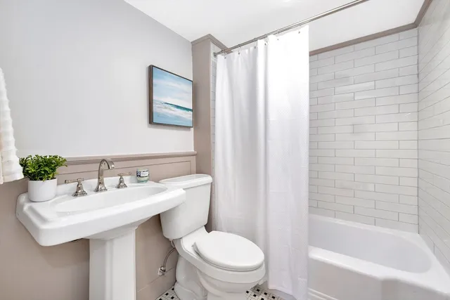 a bathroom with a sink a toilet and shower curtain