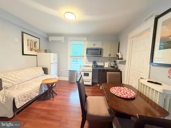 a living room with stainless steel appliances a table and chairs