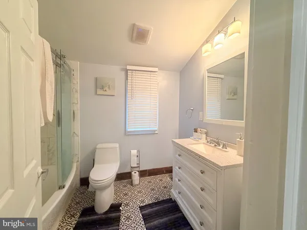 a spacious bathroom with a double vanity sink toilet and shower