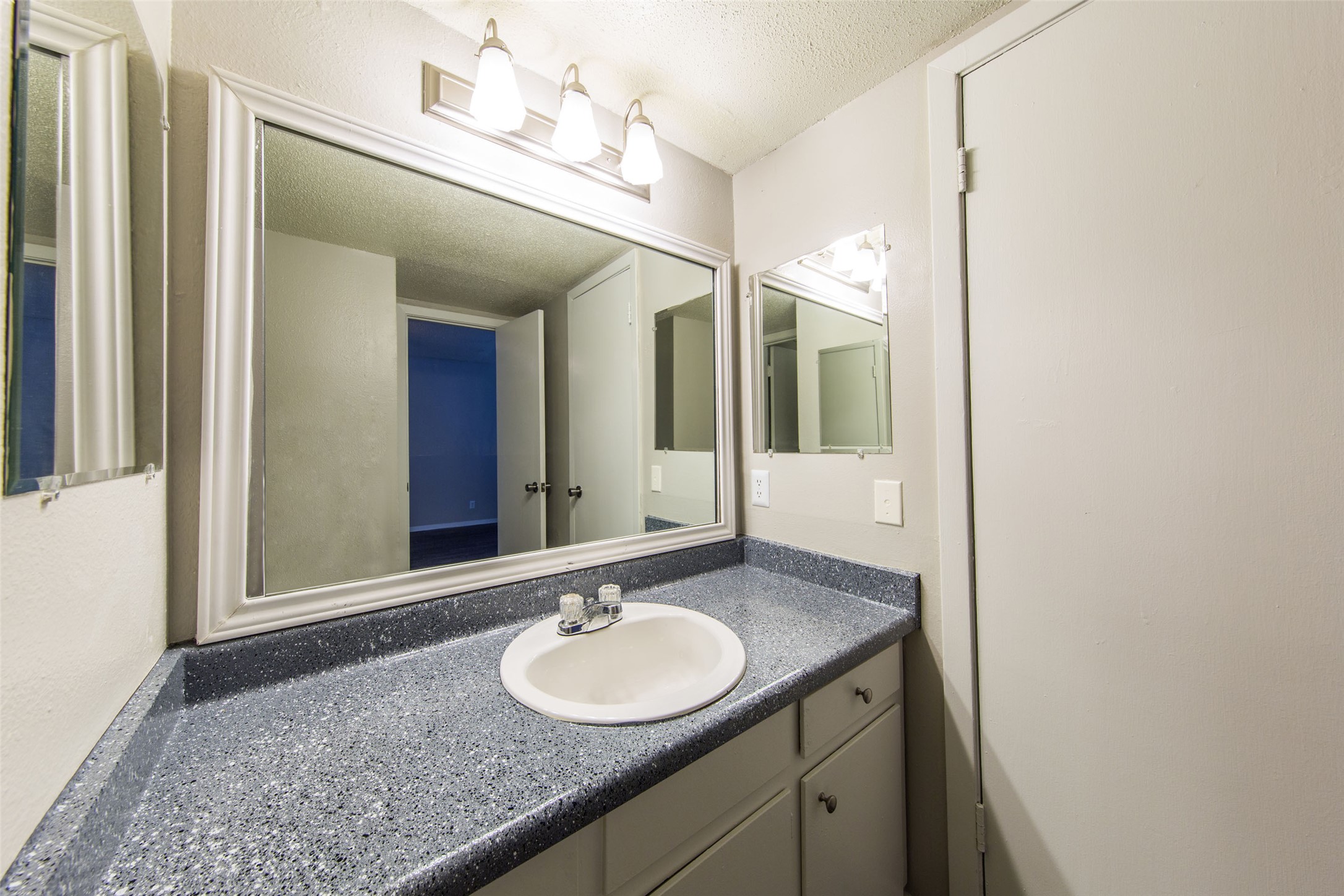 3101 Tom Green Street, Unit 104 Austin, TX 78705 - Photo 8 of 9 a bathroom with a granite countertop sink and a mirror