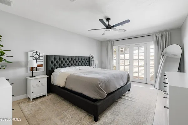 a spacious bedroom with a bed a window and dresser