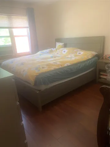 a bed sitting in a bedroom next to a window