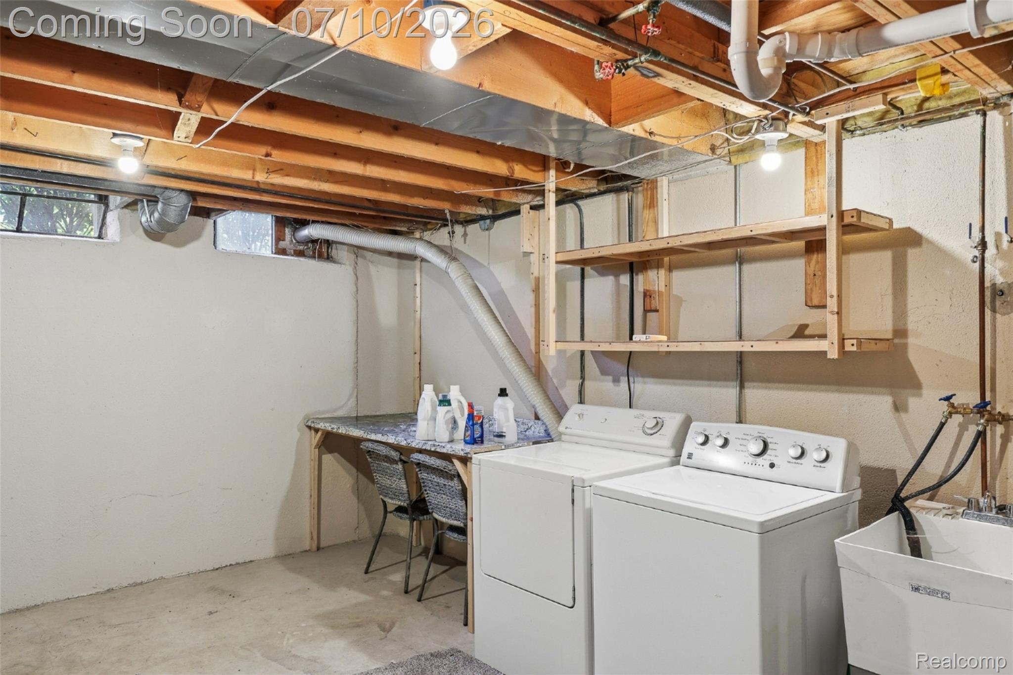 42698 Keystone Canton, MI 48187 - Photo 26 of 33 Dedicated laundry area featuring a washer and dryer, utility sink, built-in shelving, and a folding counter