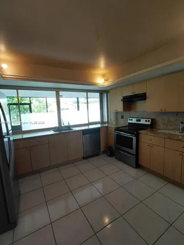 a large kitchen with a stove a sink dishwasher and a microwave