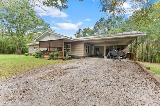 a view of a house with backyard and a tree