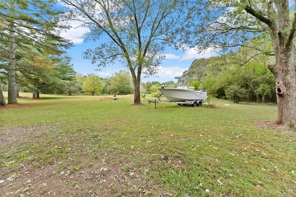 a yellow house with tall trees in front of it