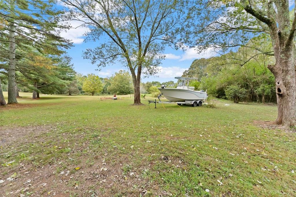 6668 Belton Bridge Road Lula, GA 30554 - Photo 4 of 20 a yellow house with tall trees in front of it