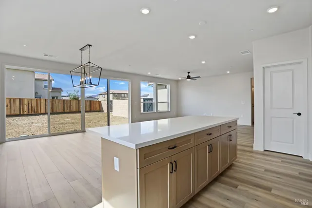 a kitchen with kitchen island a counter top space a stove and cabinets