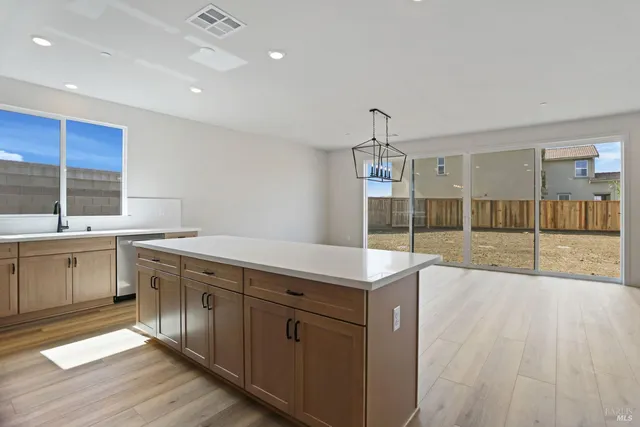 a large kitchen with granite countertop a sink and cabinets