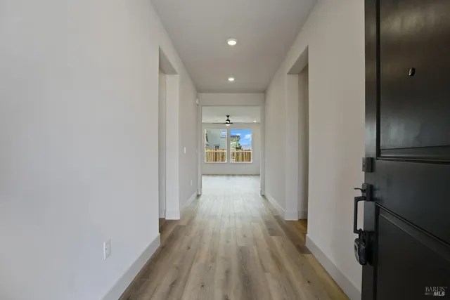 a view of a hallway with wooden floor and staircase