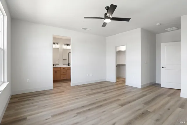 a view of a room with a ceiling fan hardwood floor and a ceiling fan