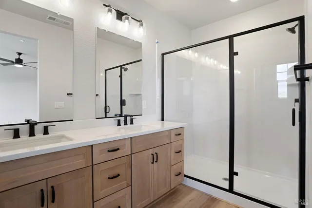 a bathroom with a double vanity sink mirror and shower
