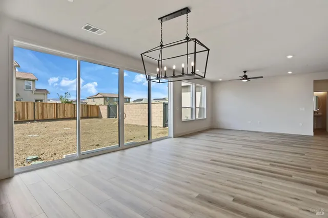 a view of a room with wooden floor and ceiling fan