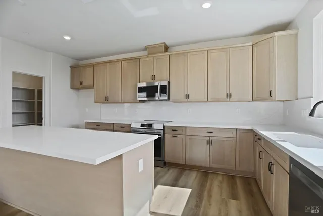 a kitchen with cabinets appliances a sink and a counter top space