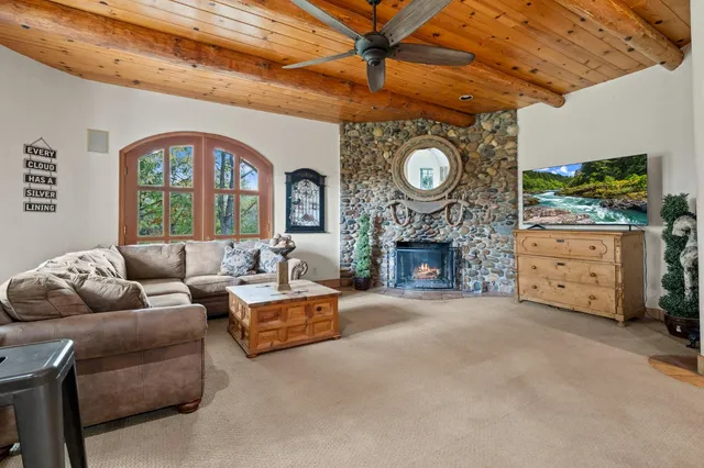 a view of a white house next to a yard with large trees