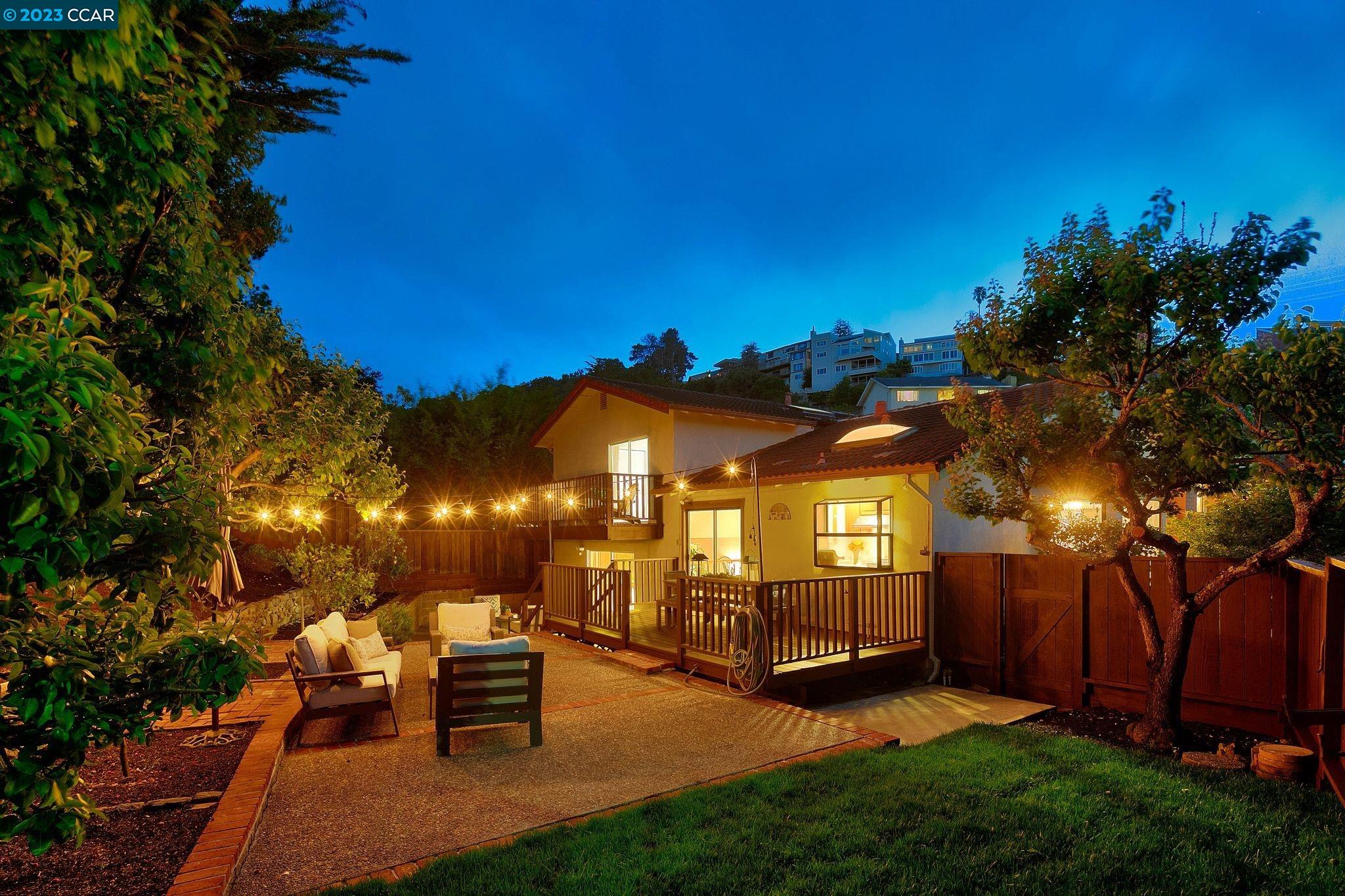 a view of a backyard with a garden and outdoor seating