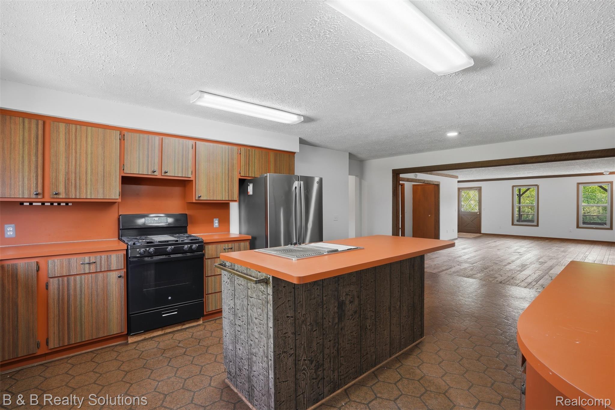 780 North Van Dyke Road, Unit APARTMENT #1 Almont, MI 48003 - Photo 14 of 28 Kitchen featuring wood-grain cabinetry with orange counters and backsplash