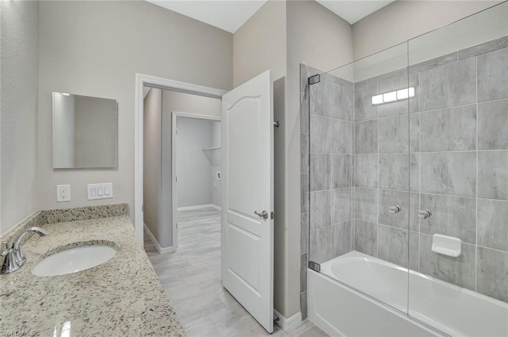 1603 Santiago Circle Naples, FL 34113 - Photo 11 of 46 a bathroom with a granite countertop sink toilet and shower