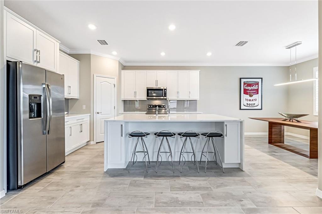 1603 Santiago Circle Naples, FL 34113 - Photo 17 of 46 a large kitchen with stainless steel appliances a refrigerator and microwave