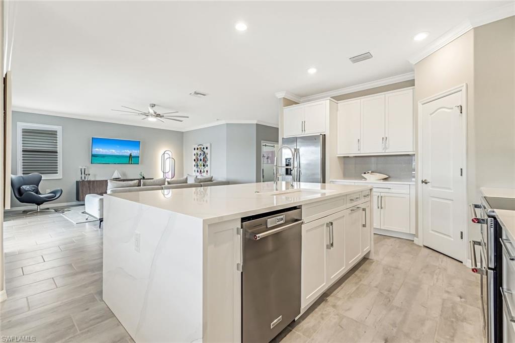 1603 Santiago Circle Naples, FL 34113 - Photo 19 of 46 a kitchen with white cabinets and sink