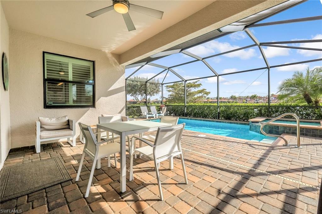 1603 Santiago Circle Naples, FL 34113 - Photo 25 of 46 a patio with yard glass top table and chairs