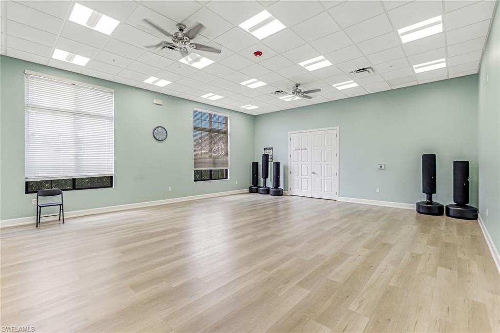 1603 Santiago Circle Naples, FL 34113 - Photo 40 of 46 an empty room with wooden floor and a ceiling fan