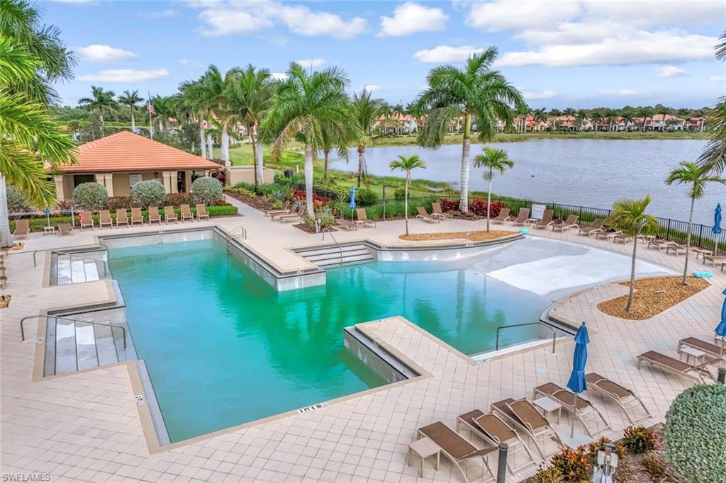 1603 Santiago Circle Naples, FL 34113 - Photo 43 of 46 a view of a swimming pool with lawn chairs under an umbrella