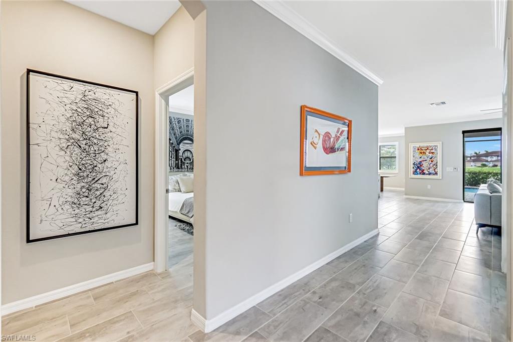 1603 Santiago Circle Naples, FL 34113 - Photo 5 of 46 a view of a hallway with wooden floor and windows