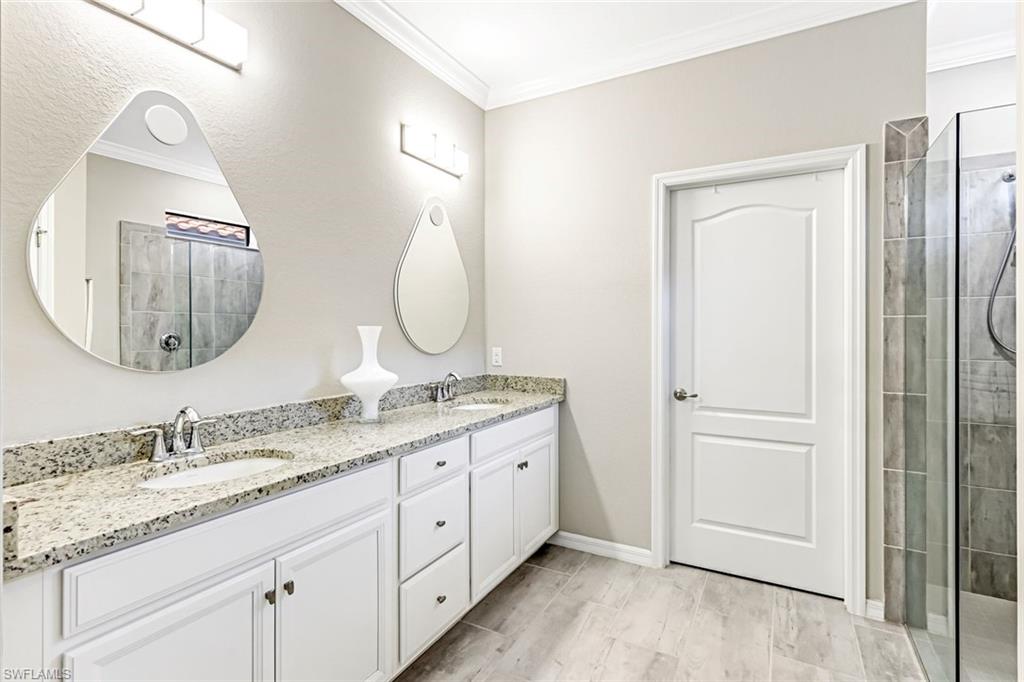 1603 Santiago Circle Naples, FL 34113 - Photo 7 of 46 a bathroom with a granite countertop double vanity sink and a mirror