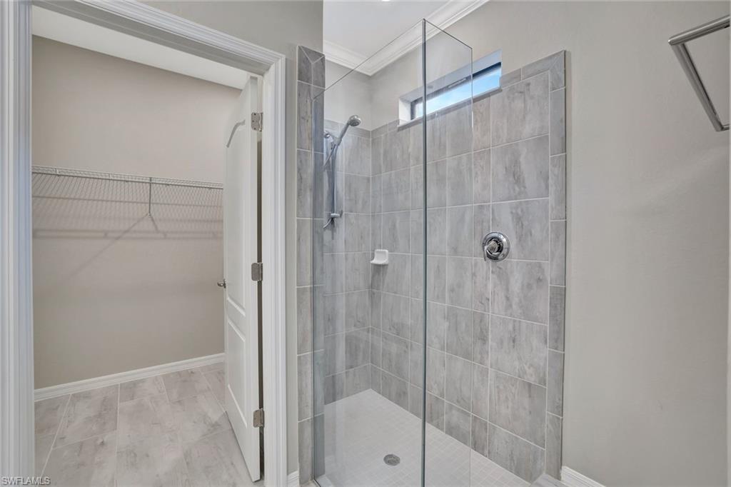 1603 Santiago Circle Naples, FL 34113 - Photo 8 of 46 a bathroom with a glass shower door