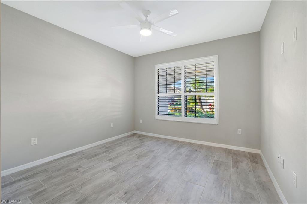 1603 Santiago Circle Naples, FL 34113 - Photo 10 of 46 wooden floor in an empty room with a window
