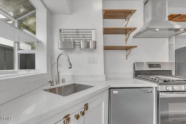 a kitchen with stainless steel appliances a sink a stove and a refrigerator