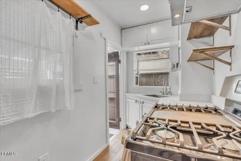 a bed sitting in a kitchen next to a bathroom