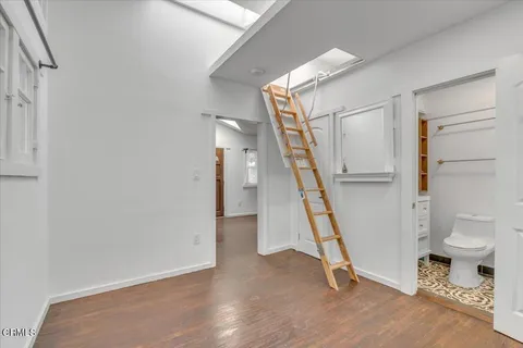 a view of an empty room with stairs and a living room