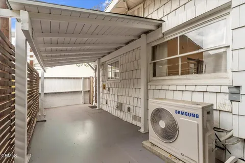 a view of a house with a yard and large tree
