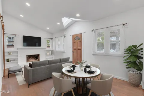 a living room with furniture a fireplace and a potted plant