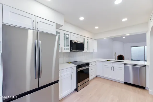 a kitchen with white cabinets and stainless steel appliances