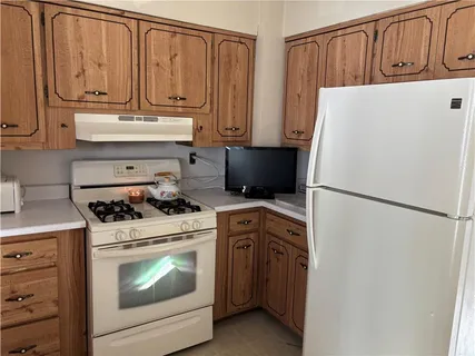 a white refrigerator freezer and a stove sitting inside of a kitchen