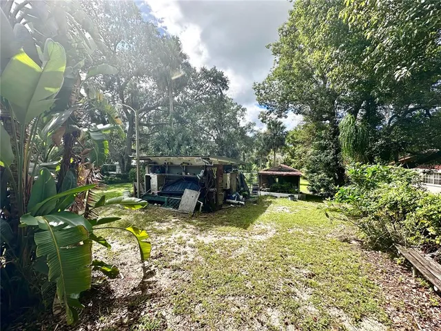 a view of a white house with a patio and a yard