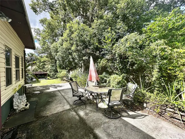 a view of green field with trees in the background