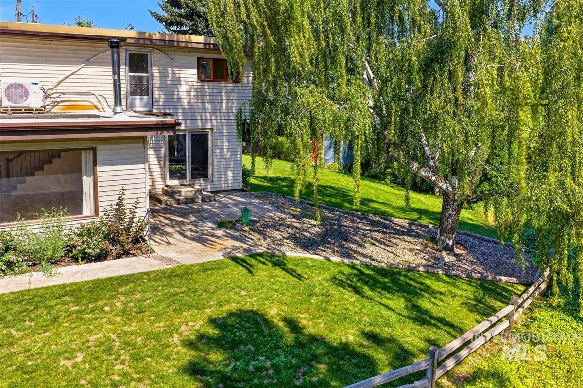 1071 Reynolds Road Princeton, ID 83857 - Photo 40 of 43 Spacious exterior featuring a large, mature weeping birch tree, expansive green lawn, and a split rail fence