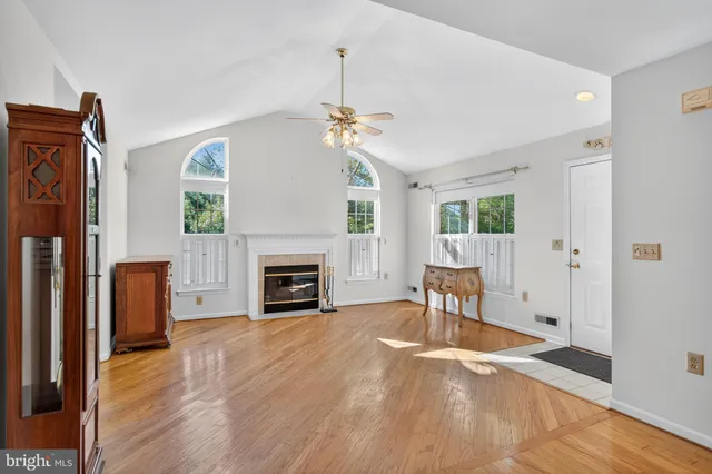 a view of a livingroom with a fireplace a chandelier and wooden floor