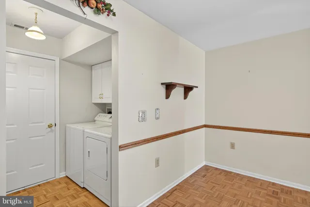 a view of storage and utility room with closet wooden floor and windows