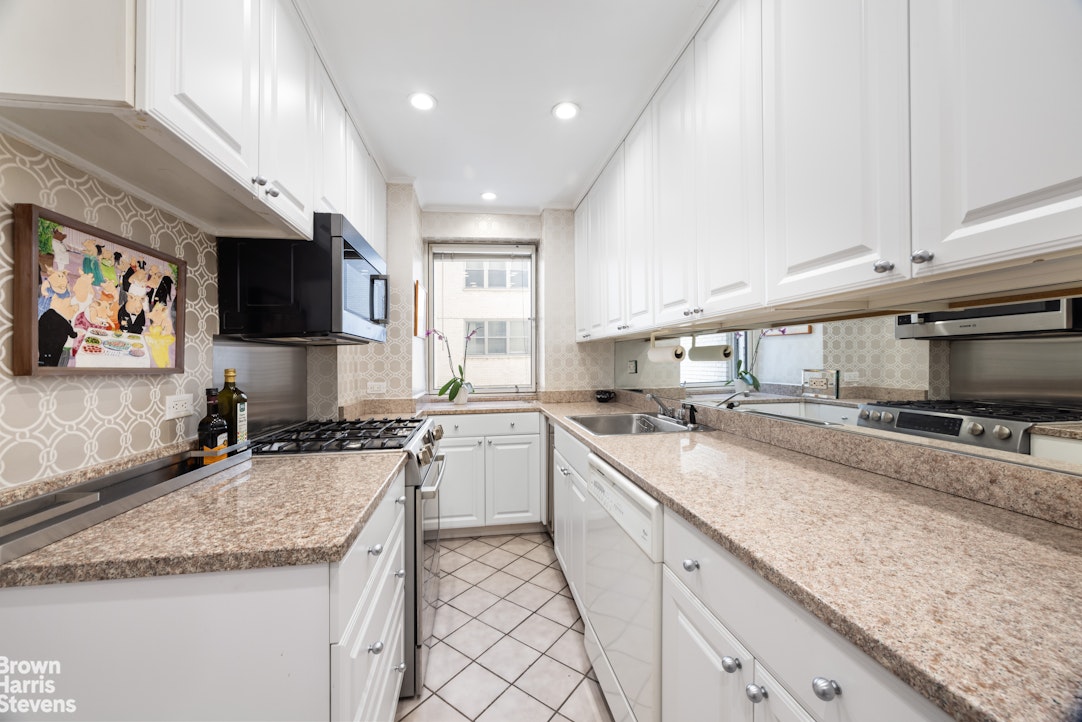 3 East 71st Street, Unit 5A Manhattan, NY 10021 - Photo 6 of 8 a kitchen with stainless steel appliances granite countertop a sink a stove and cabinets