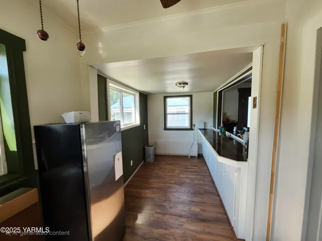 a view of a hallway with wooden floor and windows