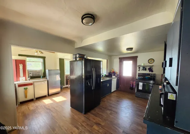 a kitchen with stainless steel appliances wooden floors and refrigerator