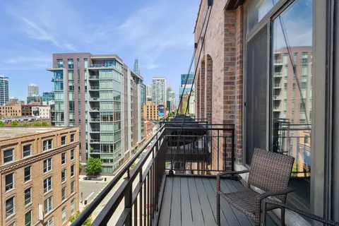 a view of balcony with wooden floor and fence
