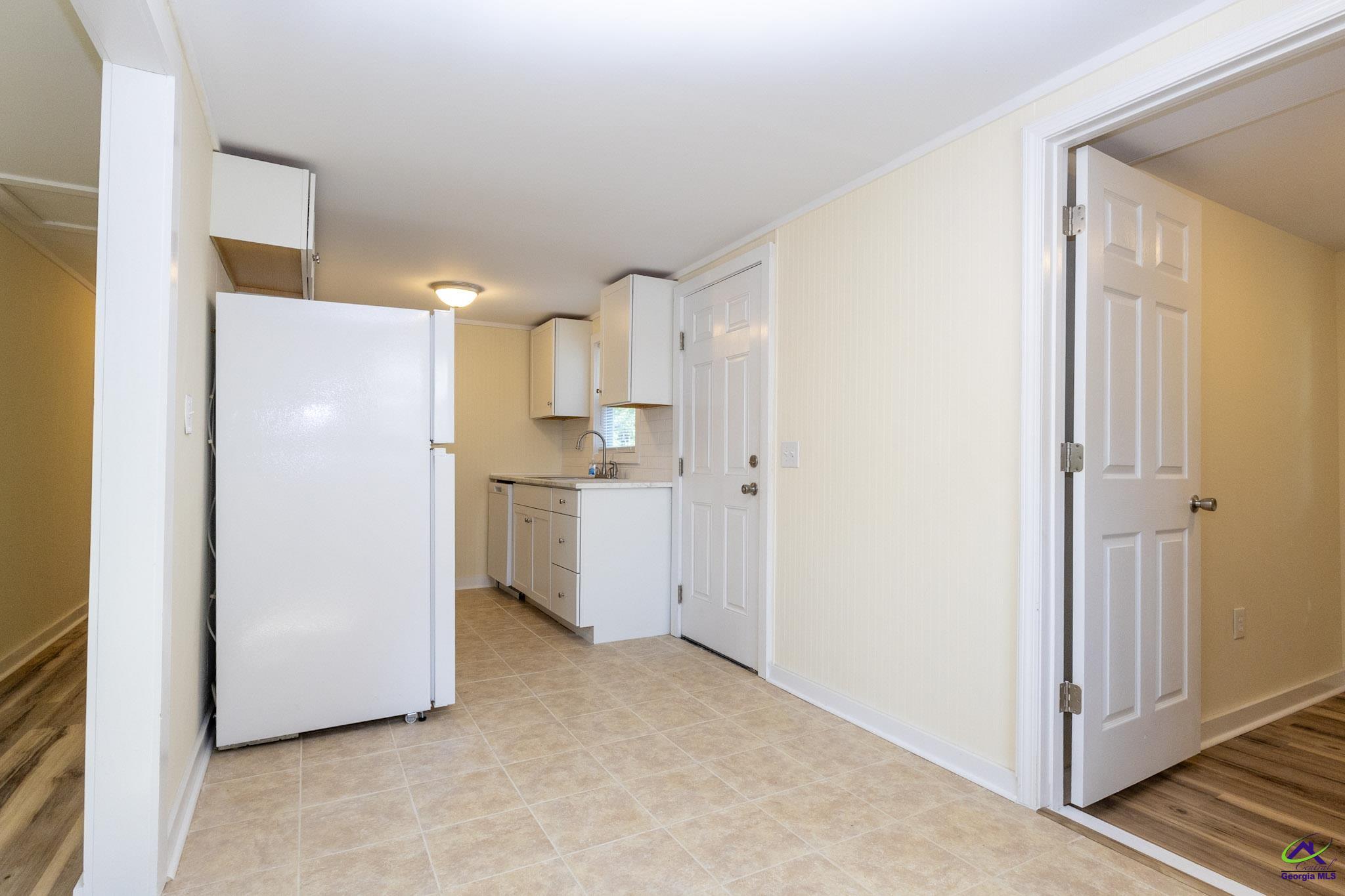 156 Churchwell Road Cochran, GA 31014 - Photo 8 of 20 a view of a kitchen with refrigerator and white cabinets